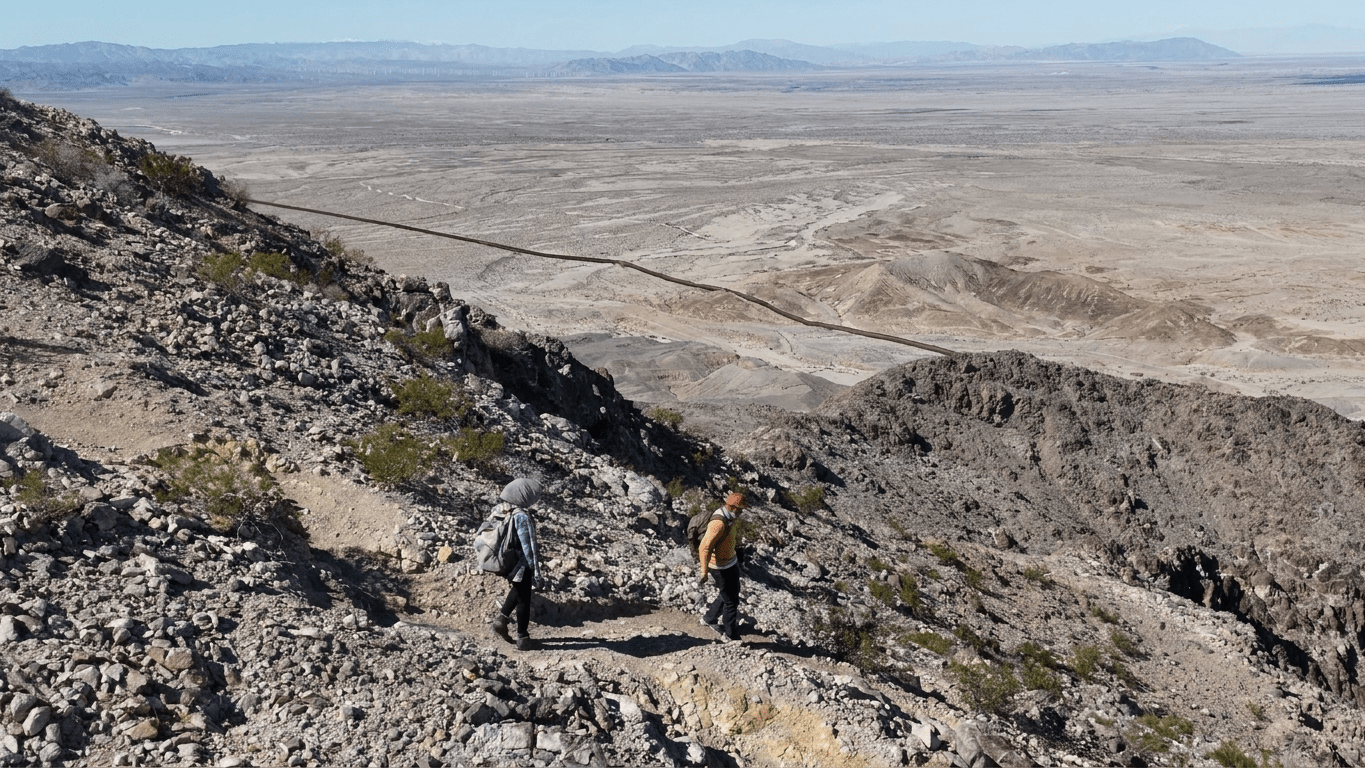 Ascenso al Cerro El Centinela: miradores con vistas a Mexicali y Laguna Salada Senderistas ascendiendo el Cerro El Centinela con vista al valle de Mexicali al fondo